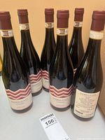 Six bottles grouped showing front and one back label with price tag in foreground