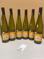 Front view of six identical wine bottles showing main labels