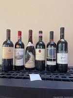 Front view of all six wine bottles showing labels and sealed tops