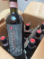 Open case showing several bottles with red wax tops and intact dividers