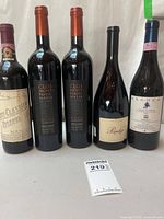 Front view of all five wine bottles showing labels