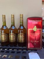 Front view of three Calvados Leriche bottles and boxed Courvoisier