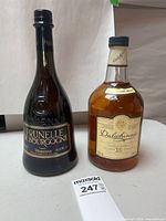 Front view of both sealed bottles: Dalwhinnie 15-Year Scotch and Vedrenne Prunelle de Bourgogne