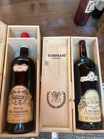 Both magnum bottles side by side in open wooden cases showing labels and TOMMASI box lid