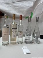 Front view of all five empty Italian grappa bottles