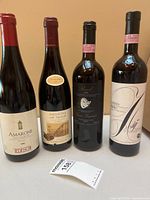 Front view of four Italian wine bottles listed