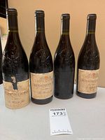 Front view of four bottles showing main labels and overall condition