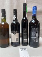Rear view of four bottles showing label details and fill levels