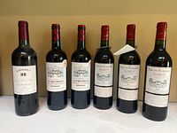 Six wine bottles front view showing labels and seals