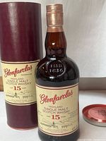 Front view of Glenfarclas 15-Year-Old bottle beside branded tube
