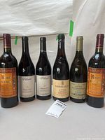 Front view of six wine bottles standing side by side
