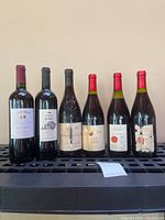 Front view of all six wine bottles on rack