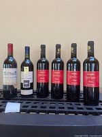 Group shot of all six wine bottles standing on rack