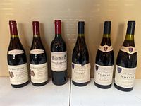 Front view of all six wine bottles showing labels and overall condition