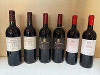 Front view of all six wine bottles standing upright
