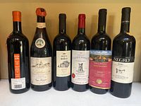 Front view of all six wine bottles displaying labels and capsules