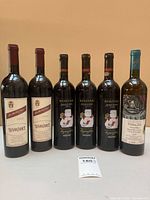 Front view of all six wine bottles standing upright