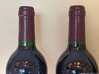 Two bottle necks with intact capsules