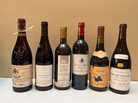 Full group shot of six French wine bottles