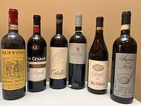 All six wine bottles standing side by side showing full labels