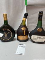 Front view of all three Armagnac bottles with lot tag