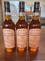 Front view of three whisky bottles showing labels and fill levels