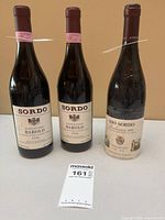Front view of all three wine bottles showing labels and overall condition
