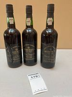 Front view three Churchill's Port bottles, labels and capsules visible