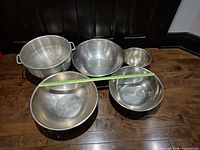 overhead view of four bowls and colander with tape measure