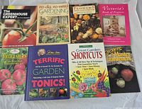 Eight of the gardening books laid out showing titles and cover conditions