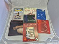 Seven yoga and spiritual wellness books laid out on white backdrop