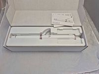 Curling iron inside molded tray with instruction booklet