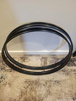 Two black bass drum hoops stacked against wall