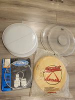 All drum heads laid out: two smooth white, two clear, woven white, sealed Duraline, boxed head
