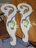 Two packaged white PVC scroll volutes on table