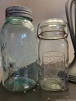 Mason’s aqua jar and Acme clear jar side by side