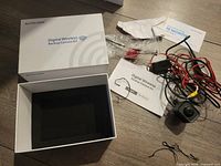 Full kit layout showing open box, camera, wires, manuals and hardware