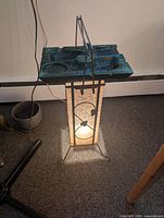Lamp illuminated showing paper shade, metal frame and ashtray top