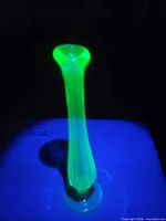 Vase glowing bright green under UV light, top view