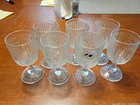 Seven clear pressed glass goblets on table