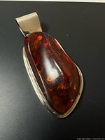 Front view showing amber cabochon and silver bezel