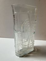 side view of clear glass vase showing raised abstract pattern