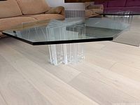 Full view of table showing octagonal glass top on clear lucite base