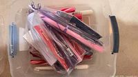 Bin of assorted wrapped taper candles in various colours