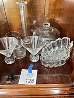 All seven clear cut glass pieces grouped in cabinet