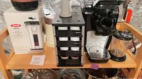 Overall lot showing OXO French press box, pod holder, unbranded brewer and carafe