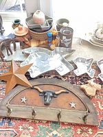 Overview showing longhorn wall rack, star décor, metal trays, vases and elephants