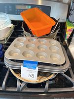 Overview of stacked muffin tins, silicone loaf pan, Bundt pan, glass dishes