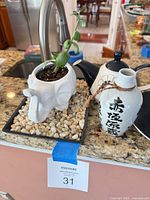 elephant planter, vase and teapot on countertop