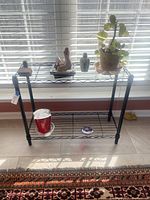 Front view of black two-tier wire rack with staging items